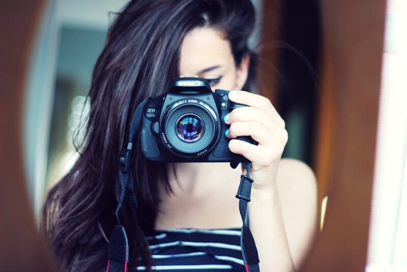 woman taking mirror selfie with camera