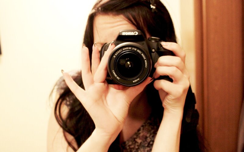 woman taking mirror selfie with camera