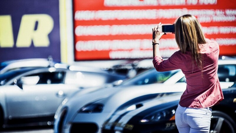 Woman taking photo at car dealership