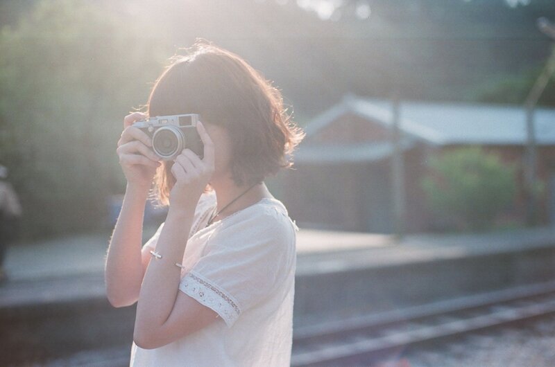 woman taking photo at train station