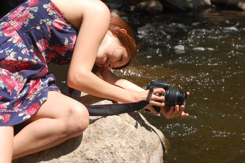 Woman taking photo by river