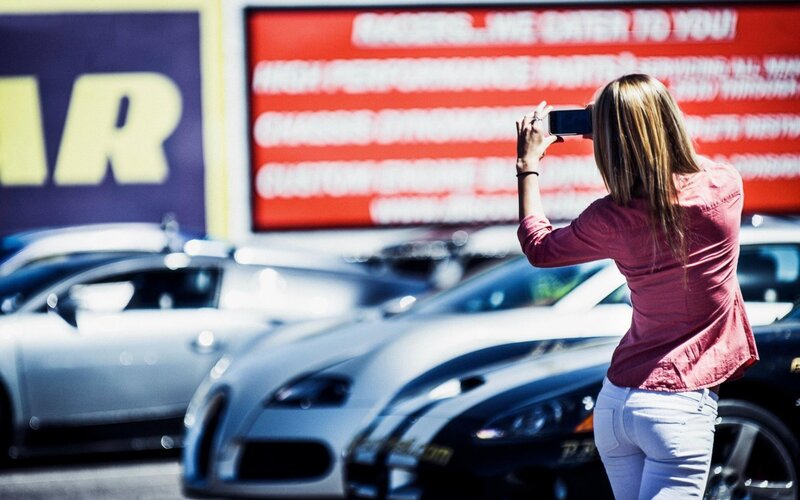 Woman Taking Photo of Cars