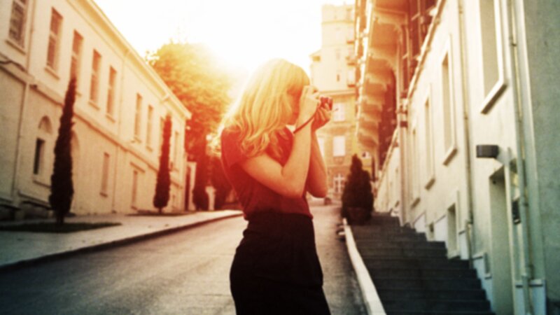 woman taking photo on street