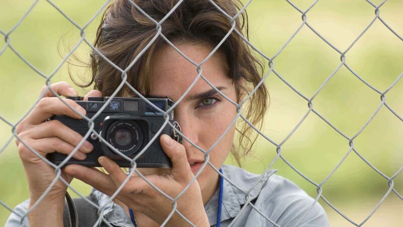 Woman taking photo through fence