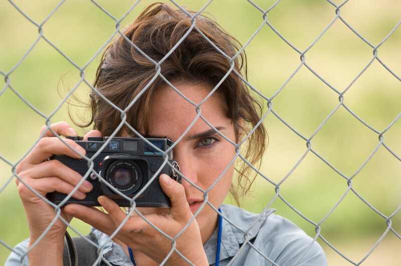 woman taking photo through fence