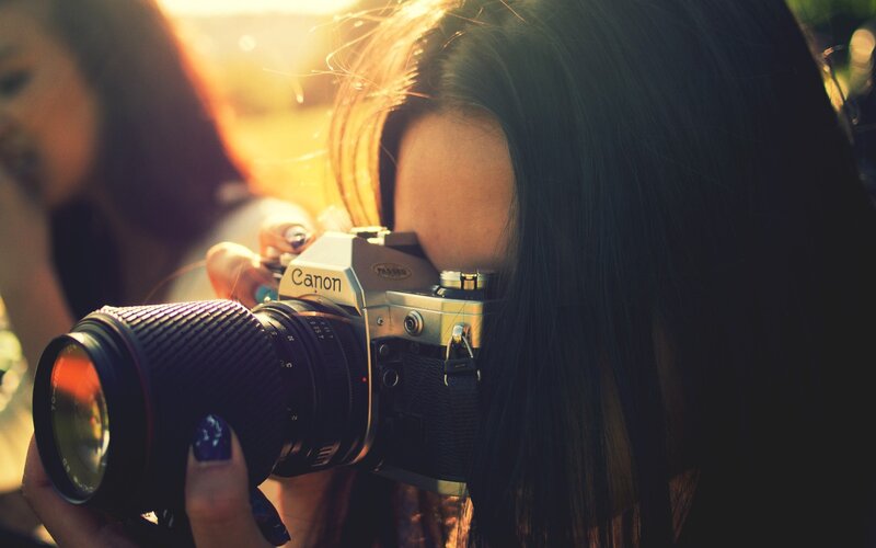 woman taking photo with canon camera