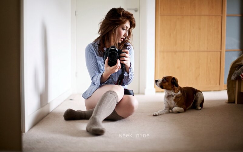 woman taking photo with dog