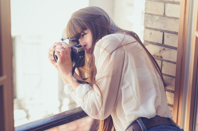 woman taking photo with vintage camera