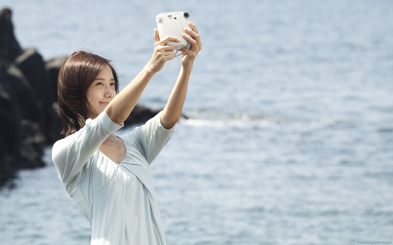 Woman taking selfie by the sea