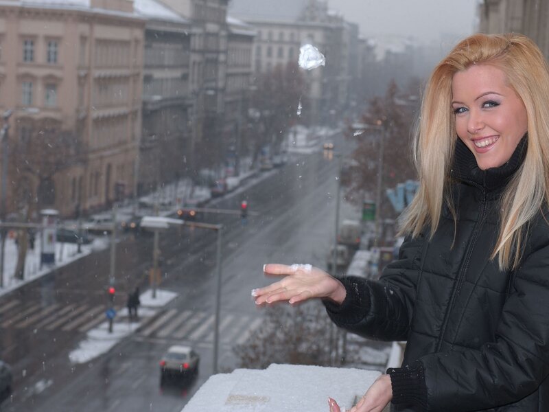 Woman throwing snowball in city