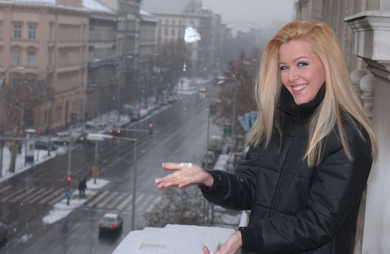 Woman throwing snowball on balcony