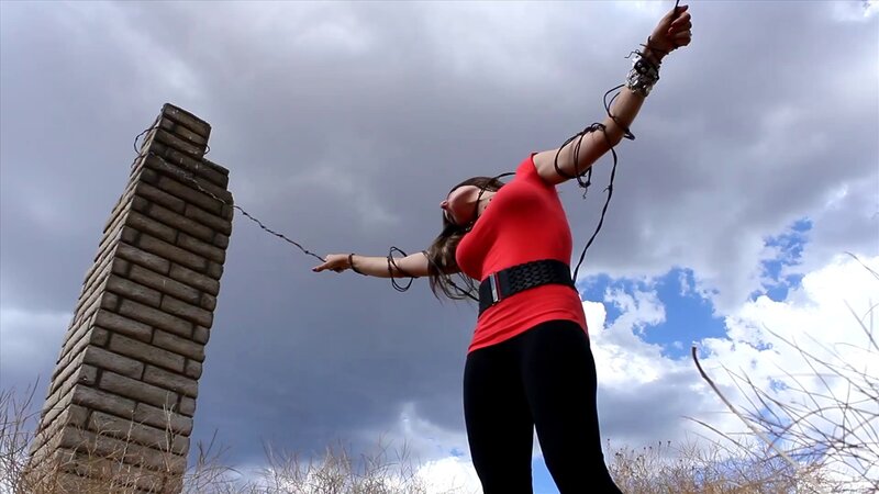 woman tied to brick pillar