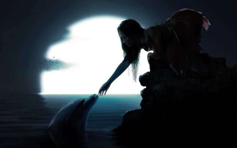 woman touching dolphin at cave entrance