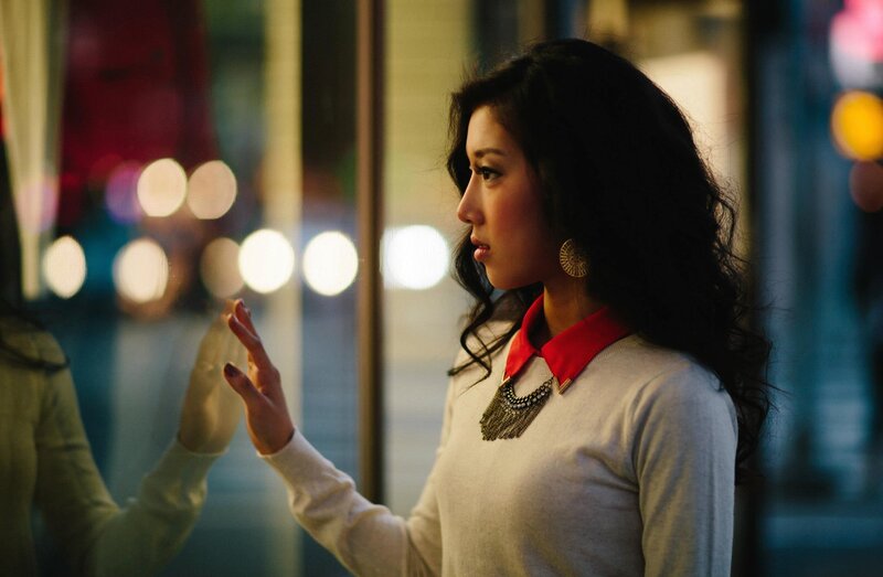 woman touching glass at night