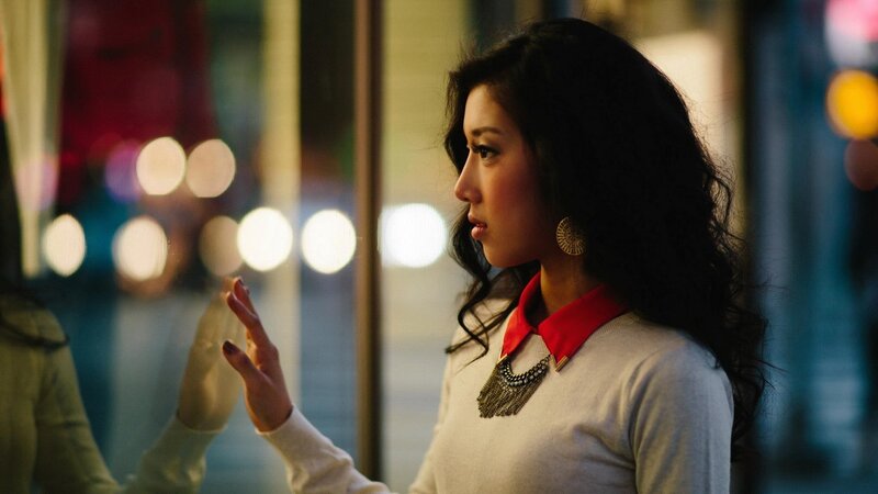 woman touching glass at night