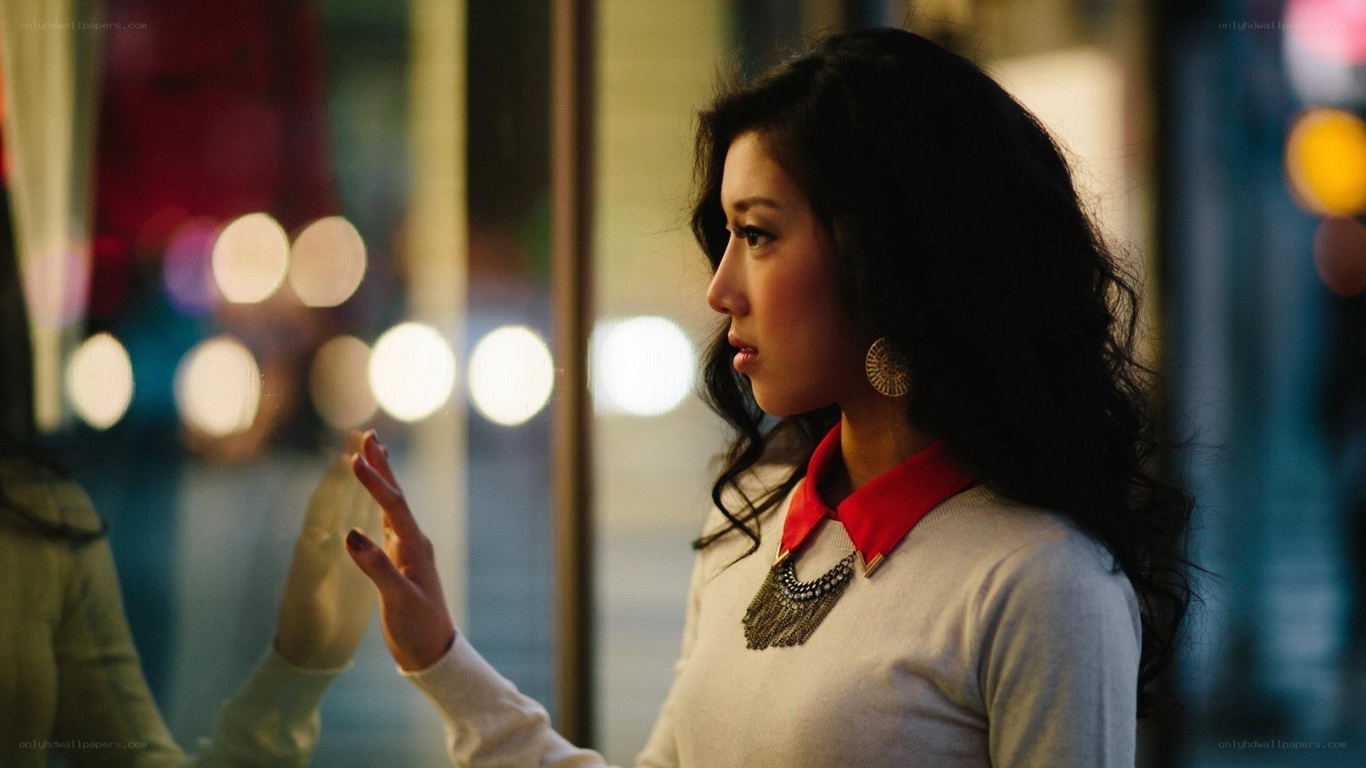 woman touching glass at night