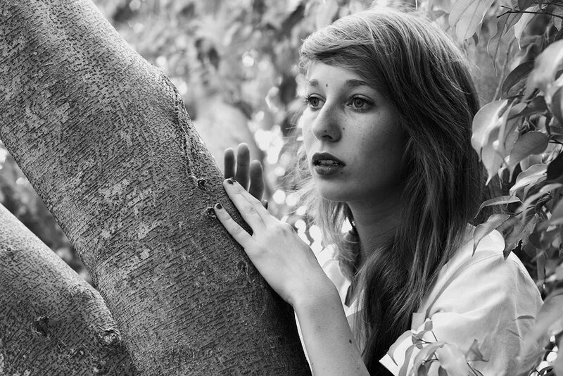 woman touching tree trunk