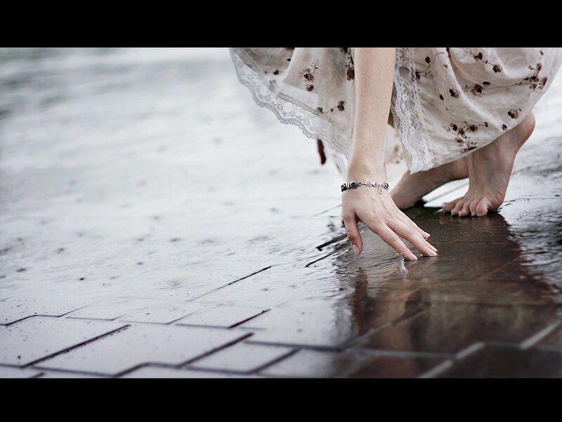 woman touching water on pavement