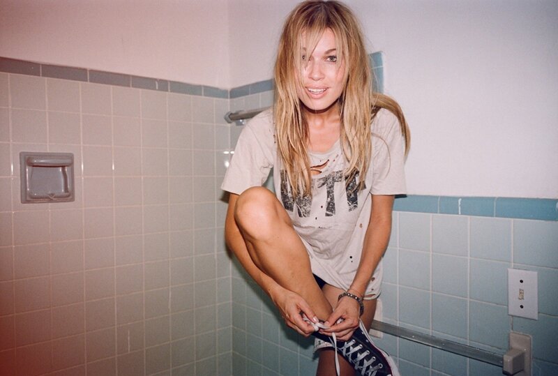 woman tying her shoe in bathroom