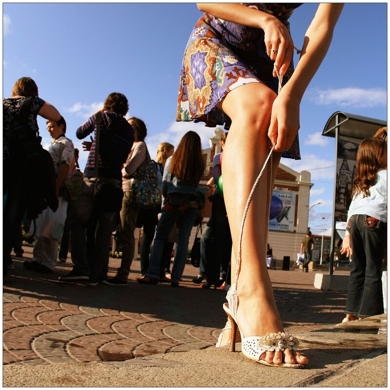 Woman tying shoe in public