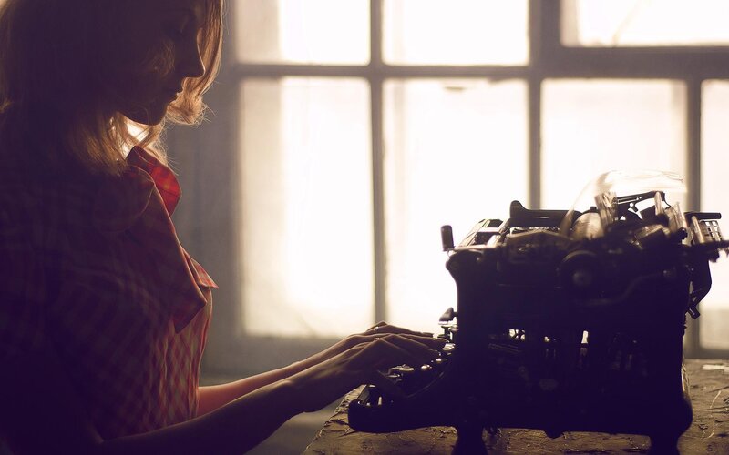 woman typing on vintage typewriter