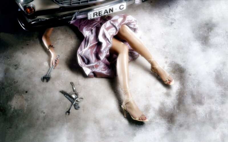 Woman under a car with tools