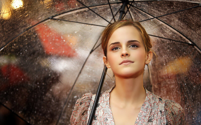 woman under a rain-soaked umbrella