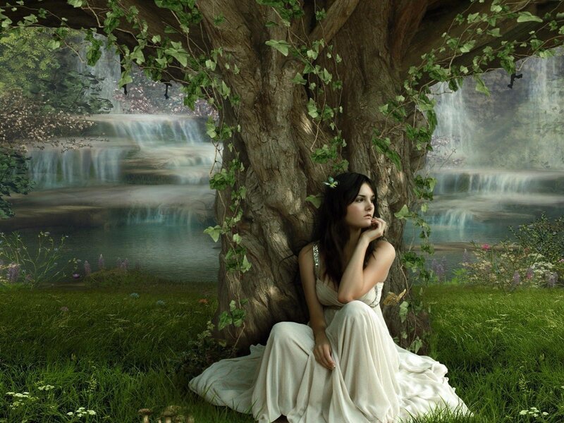 woman under a tree by waterfall
