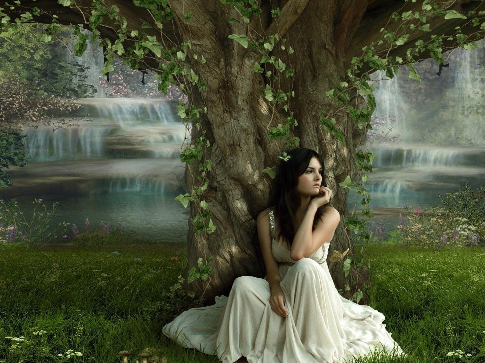 woman under a tree by waterfall