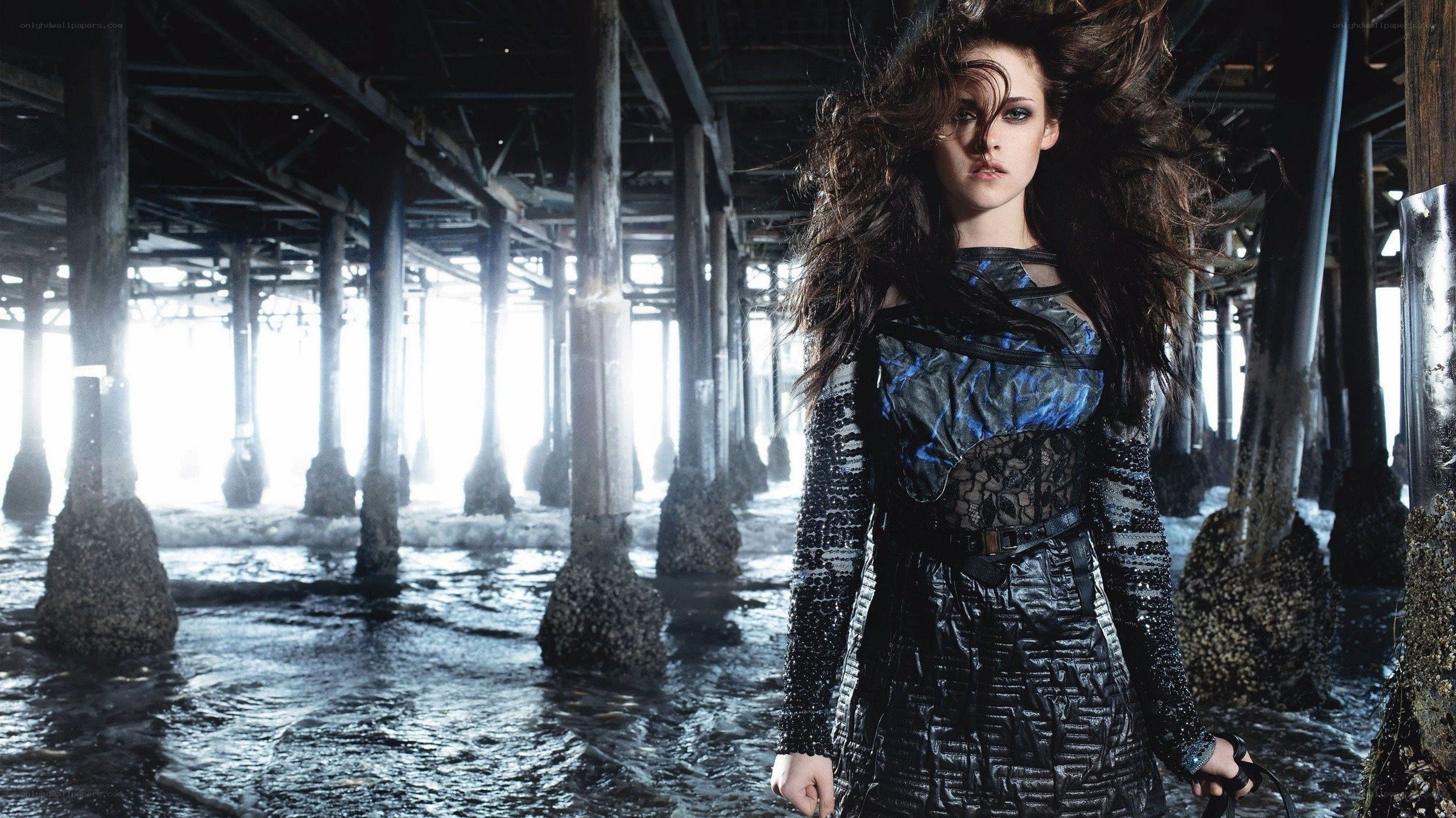 woman under pier in dramatic lighting