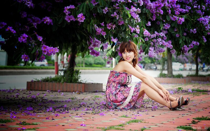 Woman under purple-flowered tree