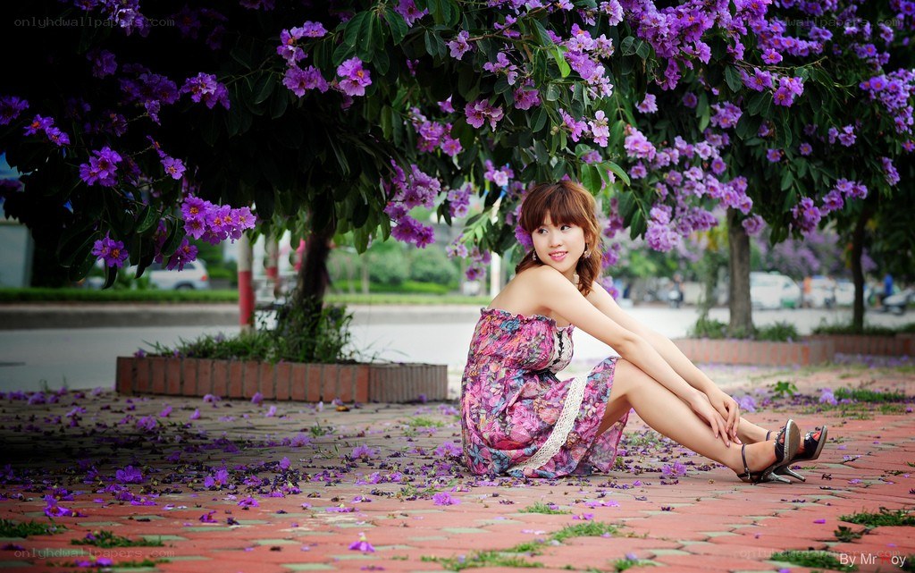 Woman under purple-flowered tree