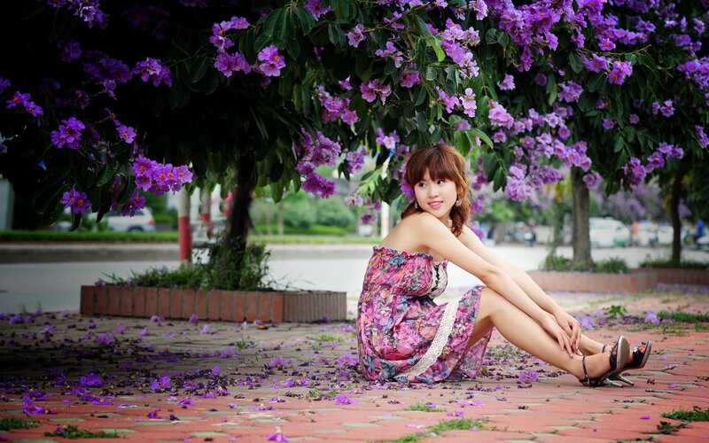 Woman under purple flowers