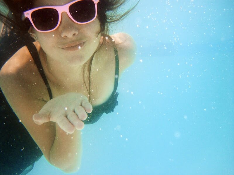 woman underwater with sunglasses