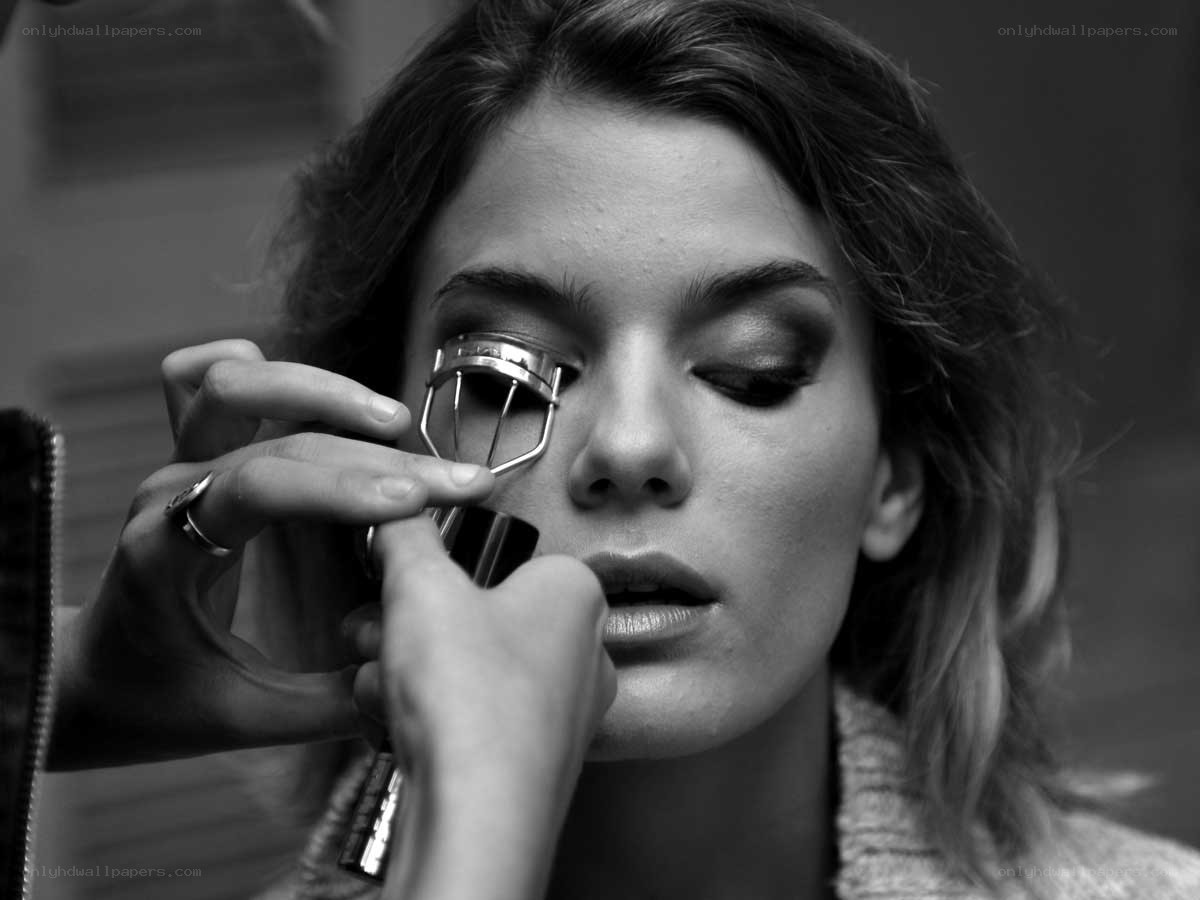 woman using eyelash curler