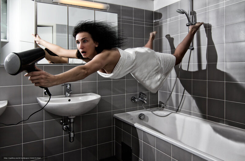 woman using hair dryer in bathroom