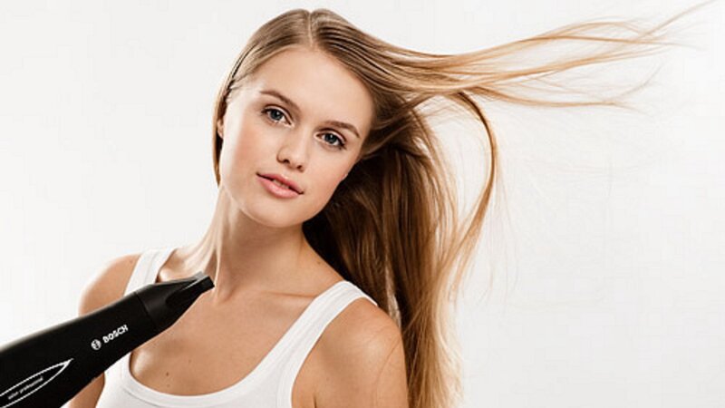 woman using hair dryer