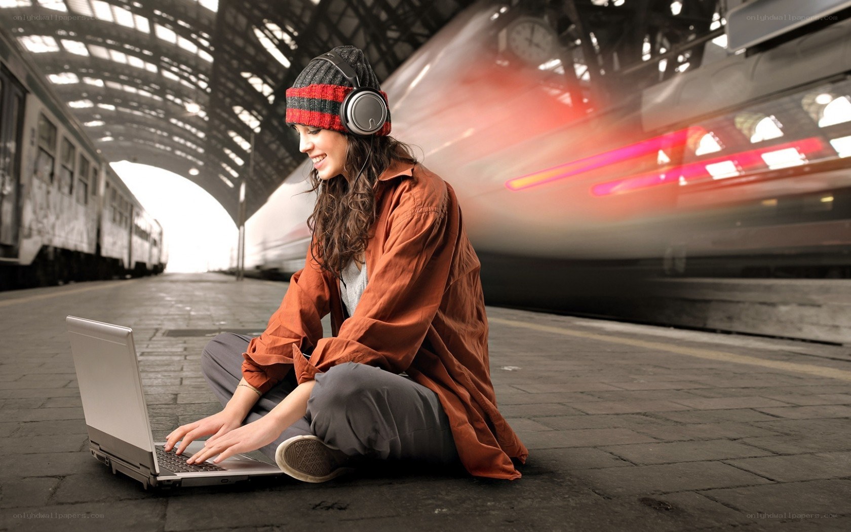 Woman using laptop at train station