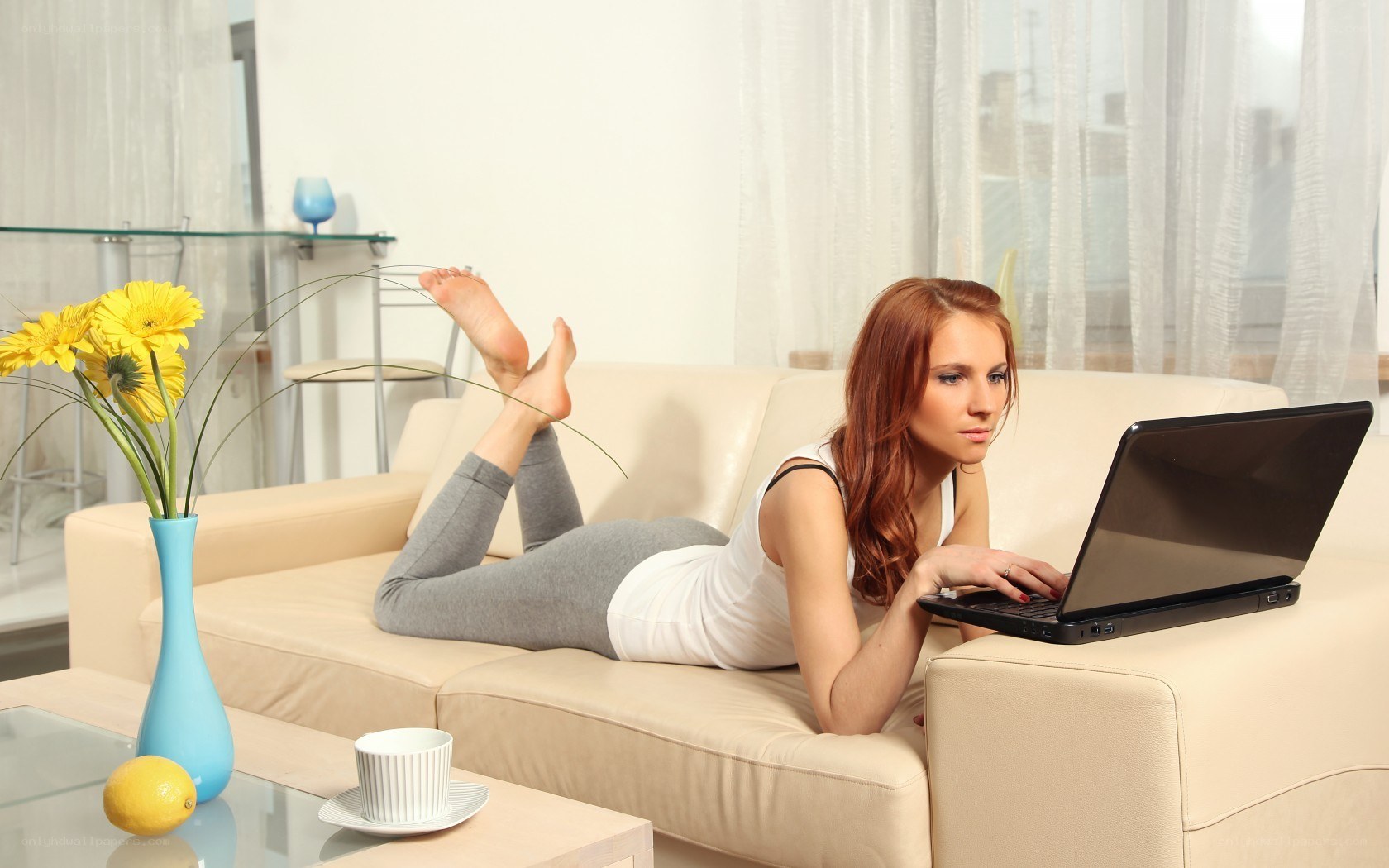 Woman using laptop on sofa