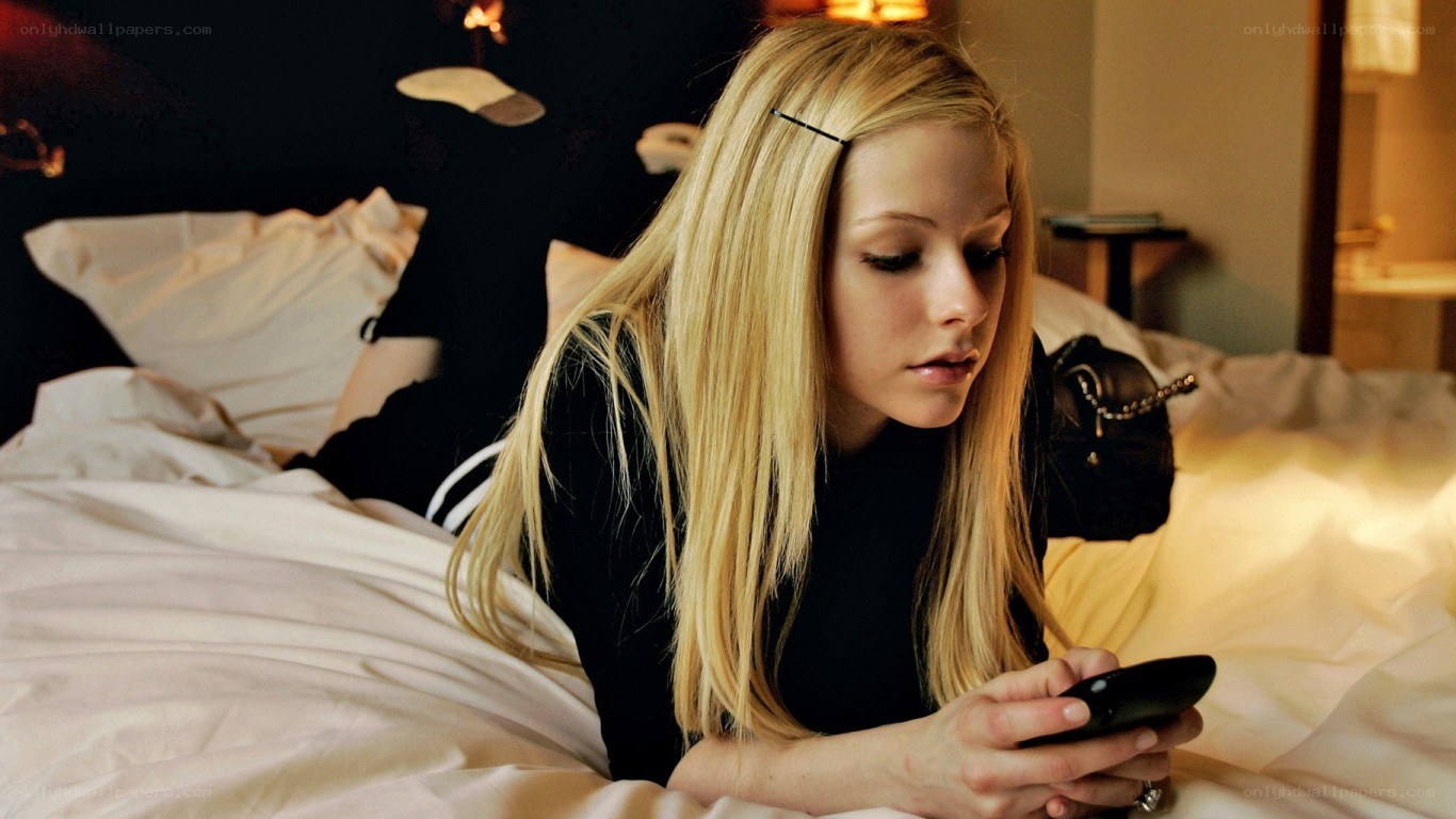 woman using phone in bed