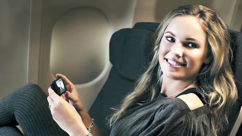 Woman using phone on airplane