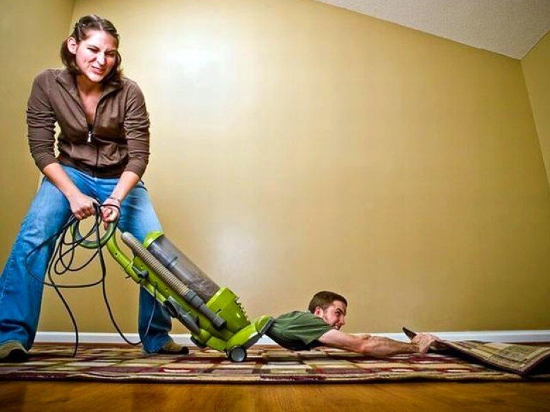 woman vacuuming man