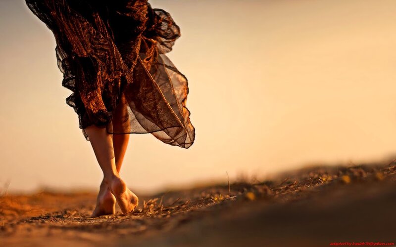 woman walking barefoot at sunset