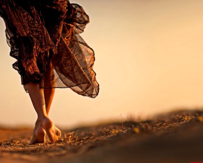 woman walking barefoot at sunset