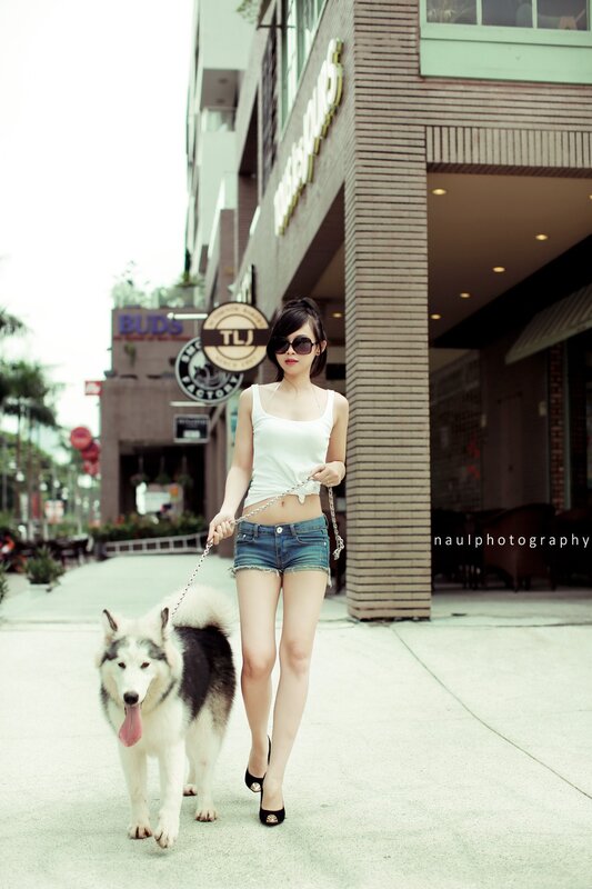 woman walking dog in city