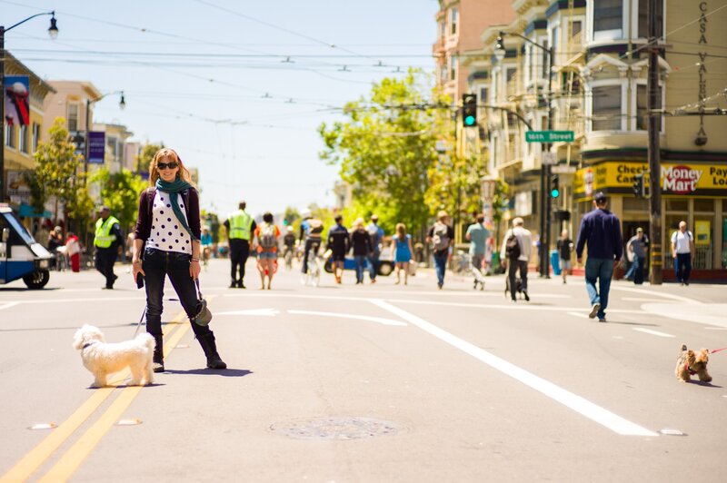 Woman walking dog on city street