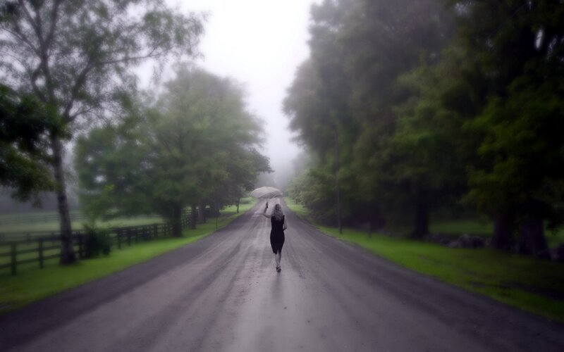 woman walking down a foggy road