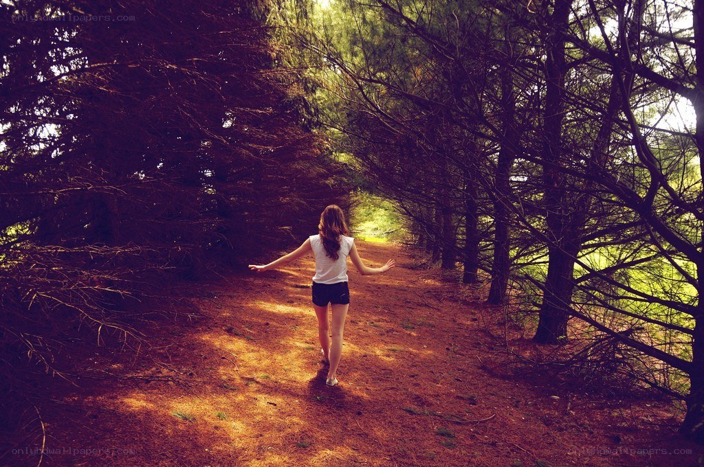 Woman walking in forest path