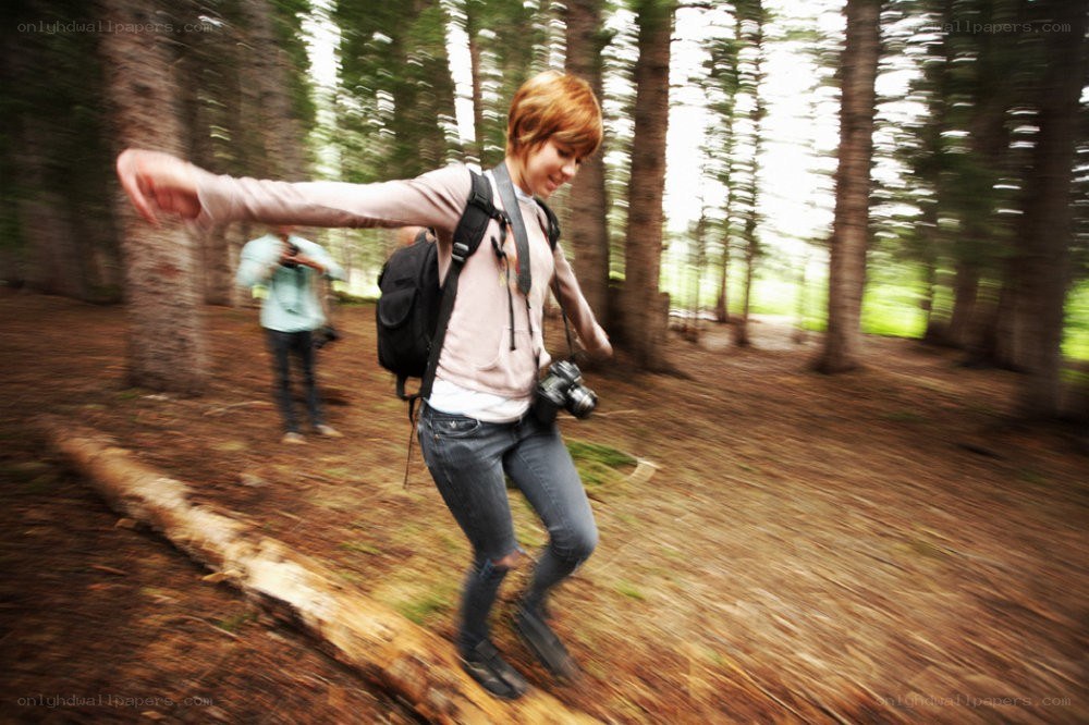 Woman walking in forest with camera