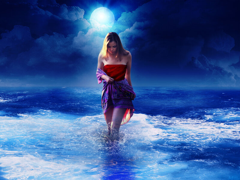woman walking in ocean at night